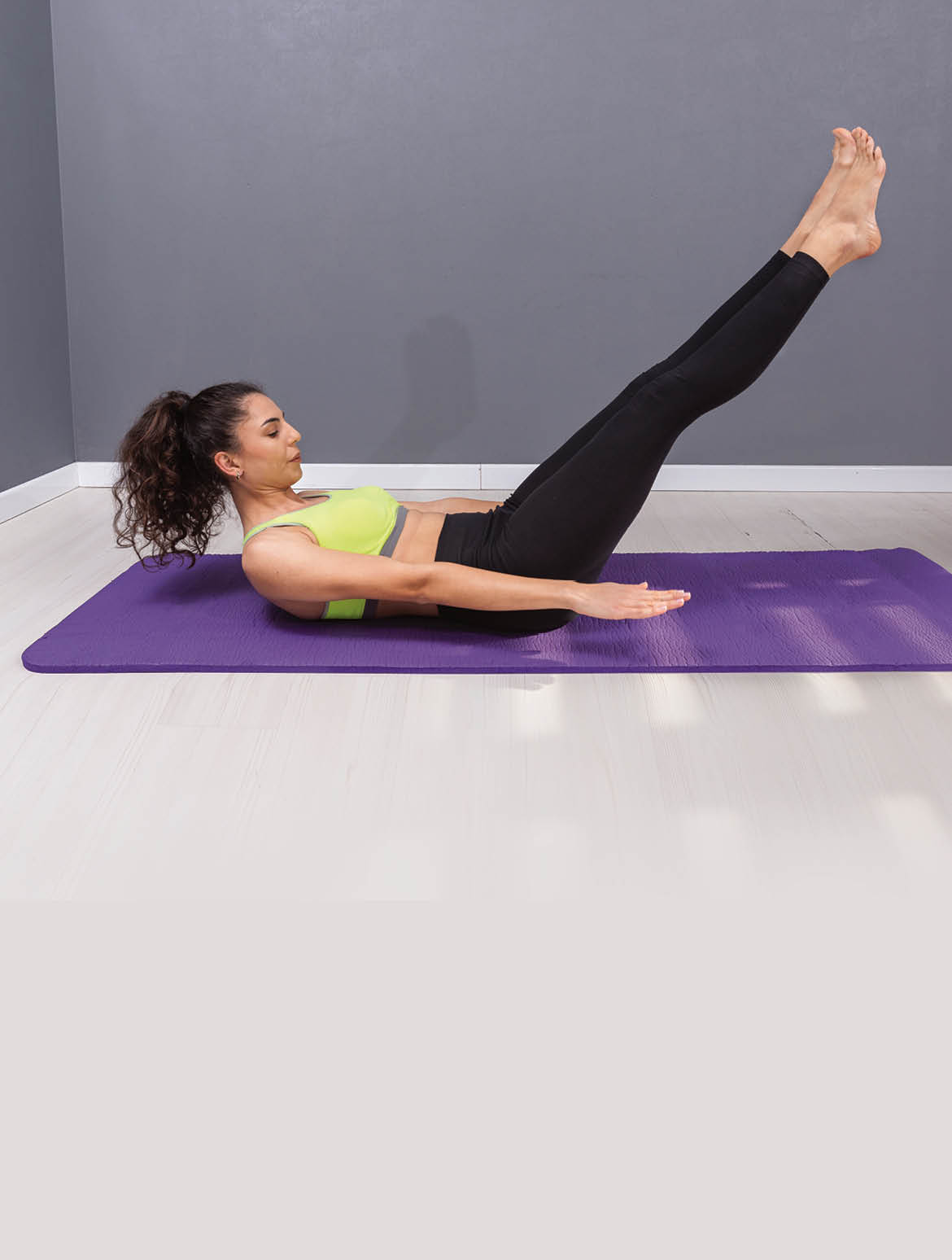 Young woman doing pilates exercise on the floor