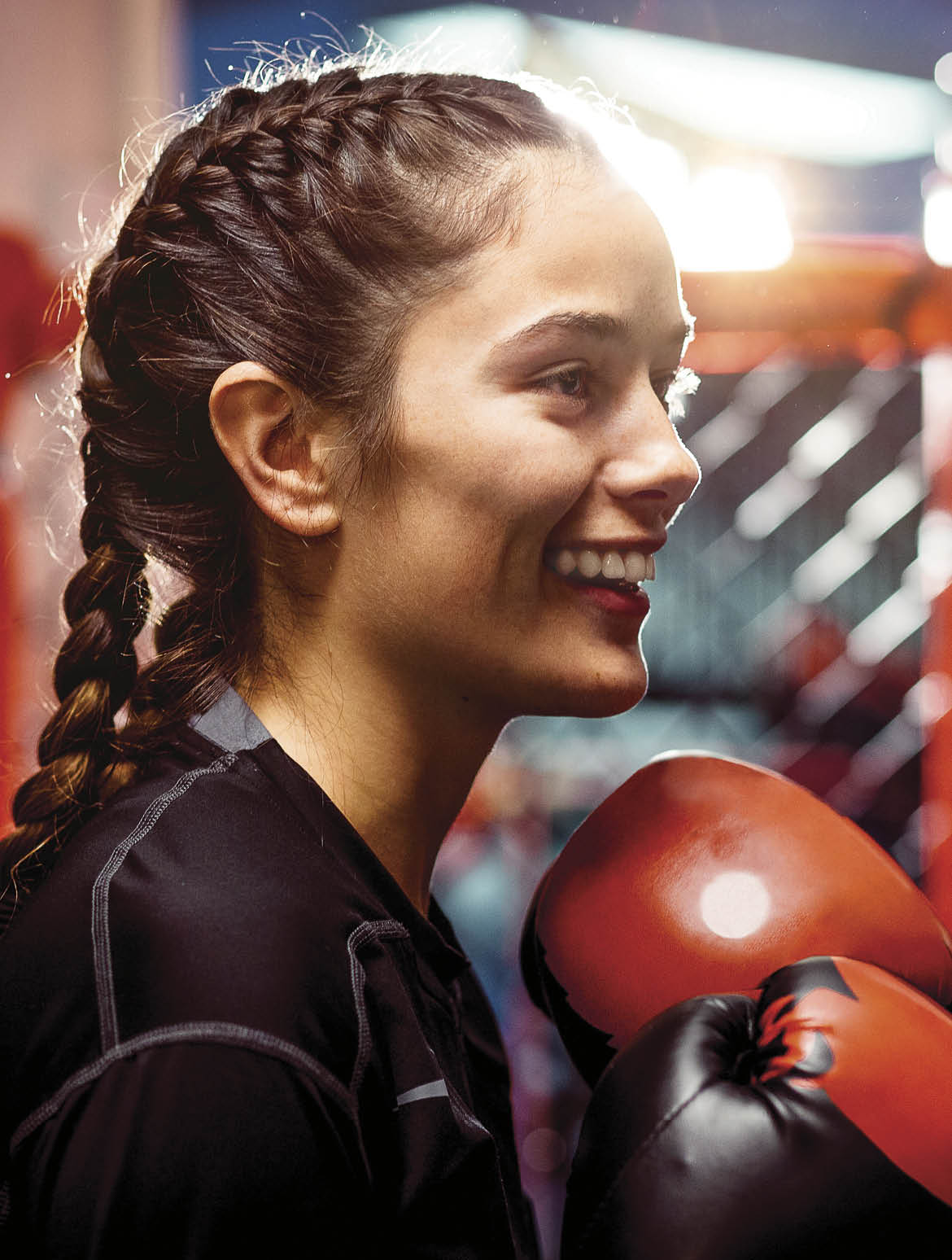 Young female boxers in a ring happily training  Low lighting with a spot light in the background  Very real and gritty  both are happy 