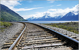 Part of Alaska railroad in the Chugach National Forest with mountain range and Turnagain arm in background  2019  iStock  blog  Coming Clean