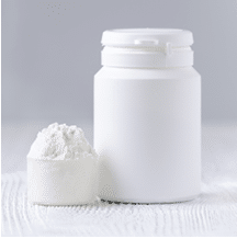 a spoon with white powder and a bottle on gray background  vertical