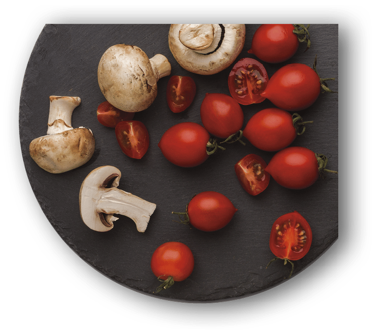 Cut tomatoes and mushrooms on rustic slate stone plate isolated over white background  Cooking healthy food, copy space, top view, cutout