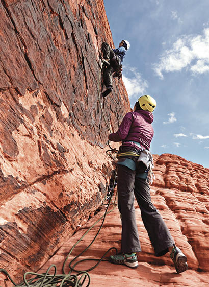 Asian woman and Caucasian man traditional (Trad) rock climbing in the Pany Wall crag section