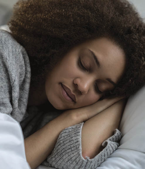 Portrait of a beautiful African American woman sleeping in bed and looking very peaceful - lifestyle concepts